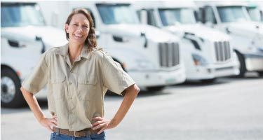 woman in front of fleet of trucks